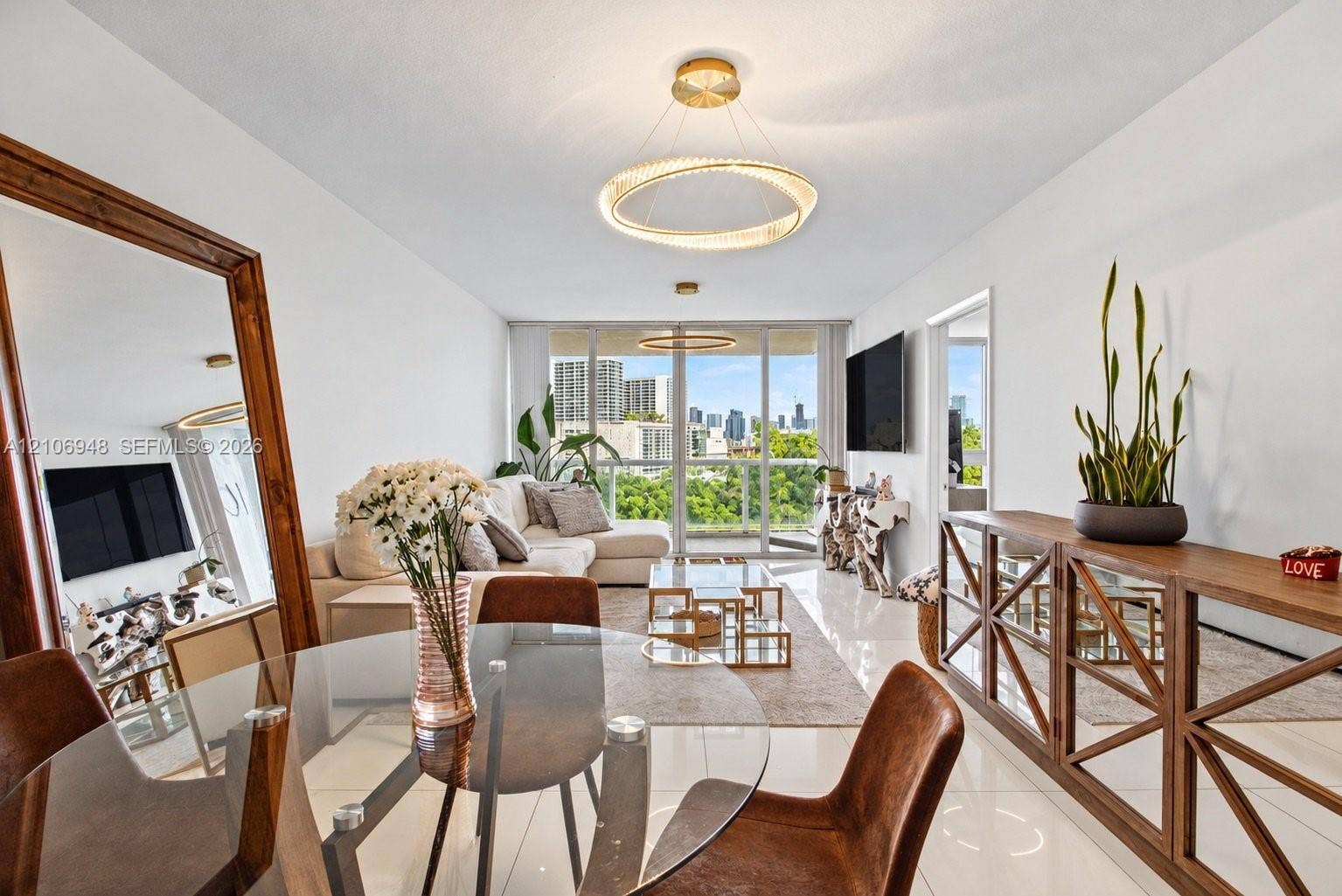 Open-concept interior featuring large-format tile flooring, polished wall finishes, contemporary circular LED light fixtures, and floor-to-ceiling glass sliding doors