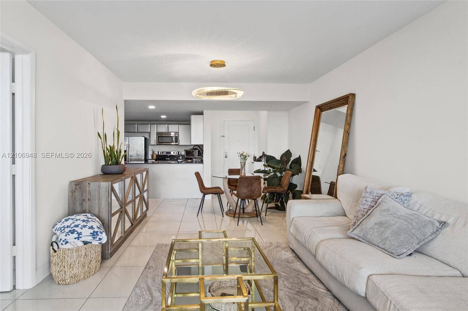 Open-concept living space with tile flooring throughout, featuring a kitchen with stainless steel appliances and a dining area