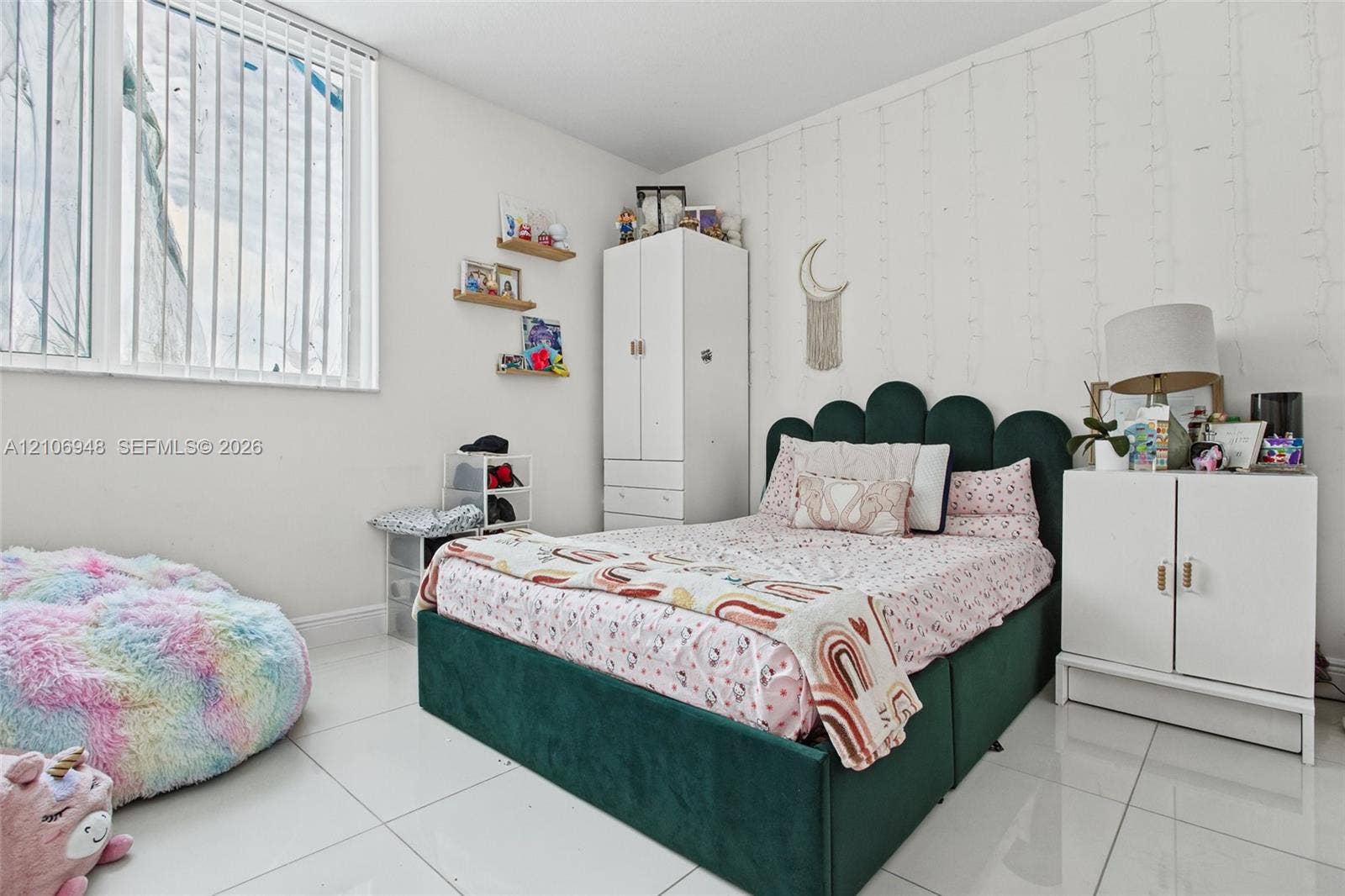 Room featuring large-format white tile flooring and floor-to-ceiling vertical blinds