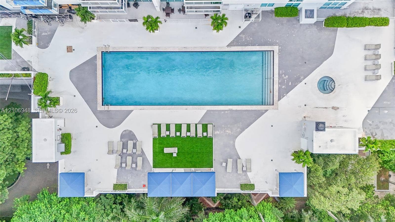 Rectangular swimming pool, circular spa, integrated hardscaped terrace, synthetic turf area, and shaded cabana structures