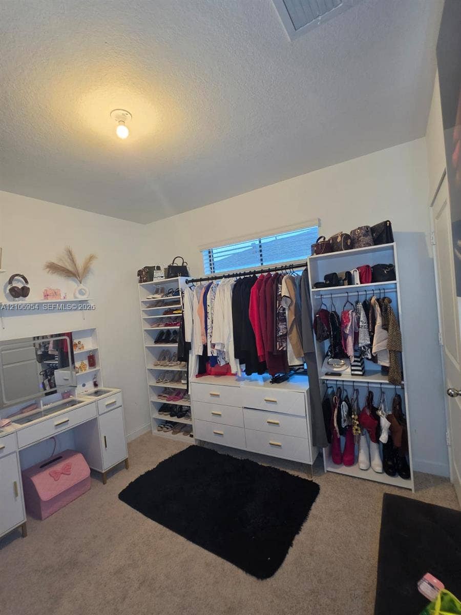 Room featuring neutral wall-to-wall carpeting and a window with horizontal blinds
