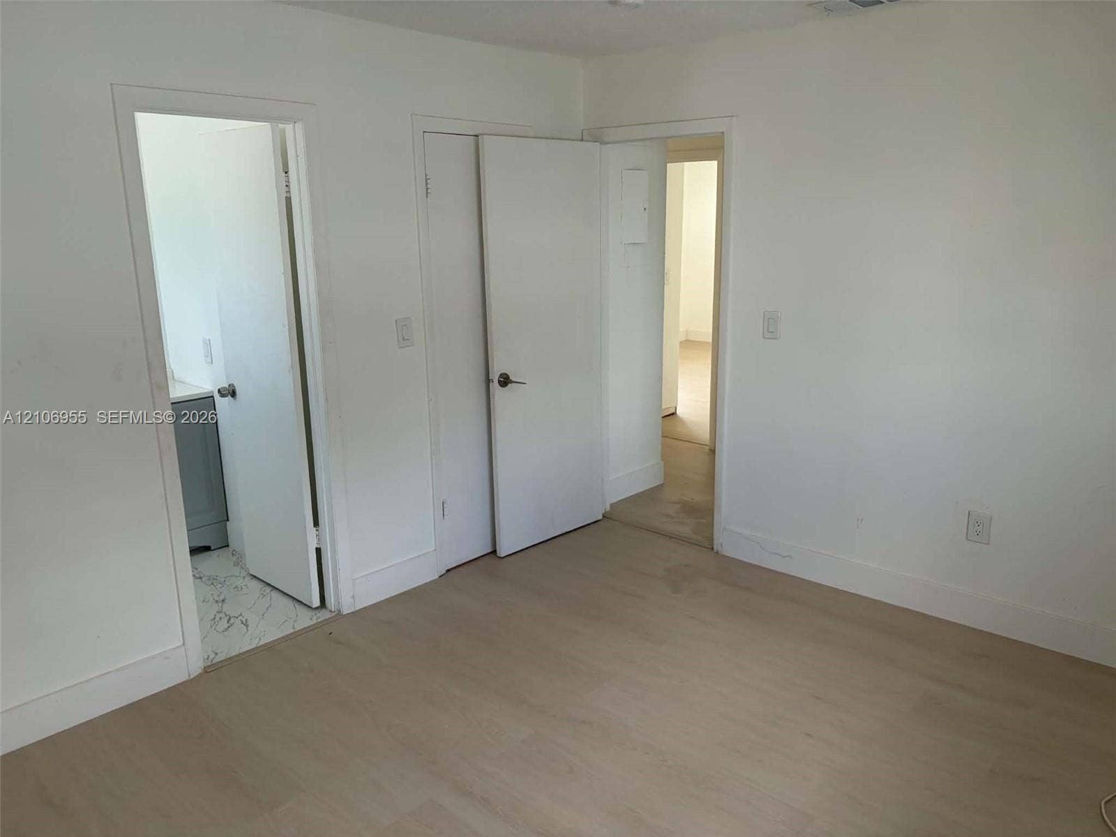Interior space featuring wood-finish flooring, white walls, and solid-core interior doors