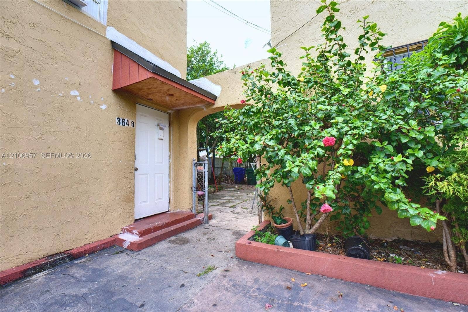 3660 NW 20th Avenue, #4, Miami, Miami, FL 33142 Stucco exterior featuring a covered entryway, paved concrete patio area, and a raised masonry planter