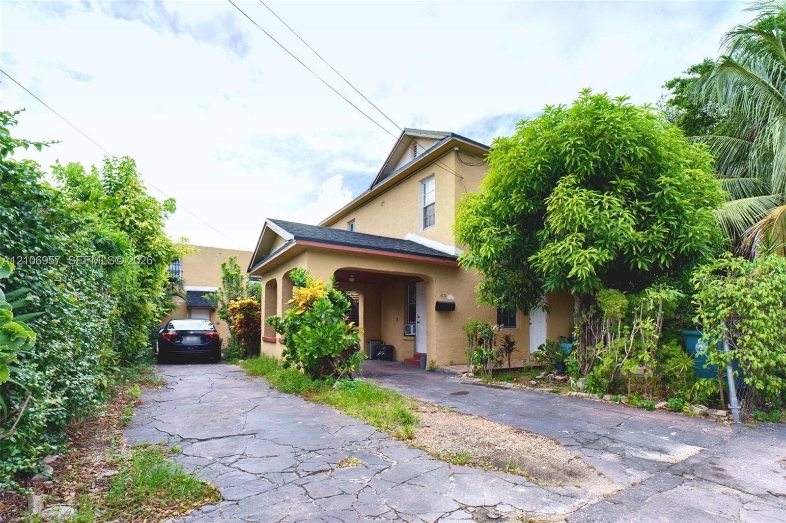 3660 NW 20th Avenue, #4, Miami, Miami, FL 33142 Two-story exterior featuring a stucco facade, covered entryway, and asphalt shingle roofing