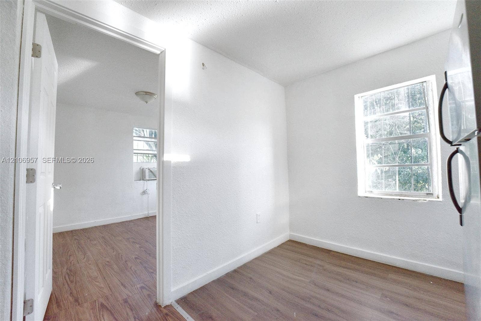 3660 NW 20th Avenue, #4, Miami, Miami, FL 33142 Interior space featuring wood-finish flooring, white walls, and multiple windows providing natural light