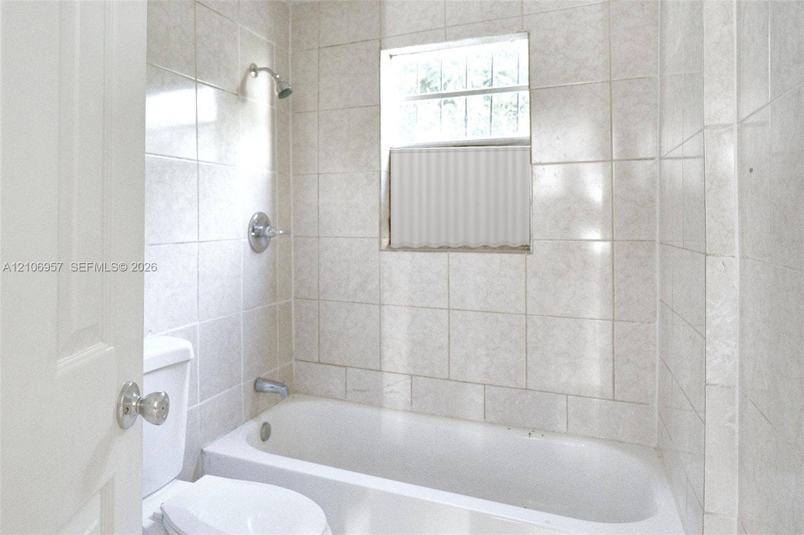 3660 NW 20th Avenue, #4, Miami, Miami, FL 33142 Tiled bath with tub and shower. Virtually staged: window treatment added digitally.