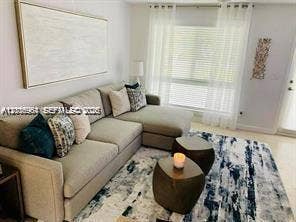 Neutral interior space featuring large windows with blinds, light-toned wall finishes, and solid surface flooring