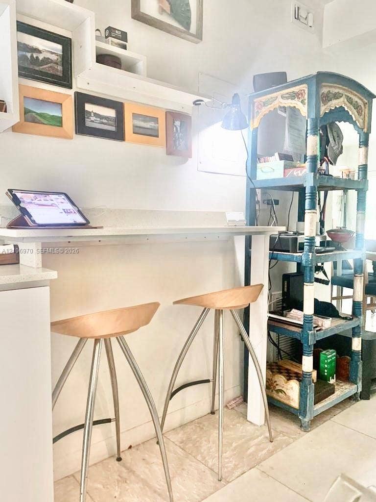 8540 Byron Avenue, #1B, Miami Beach, Miami Beach, FL 33141 Built-in white wall-mounted desk with quartz countertop and coordinating floating shelving