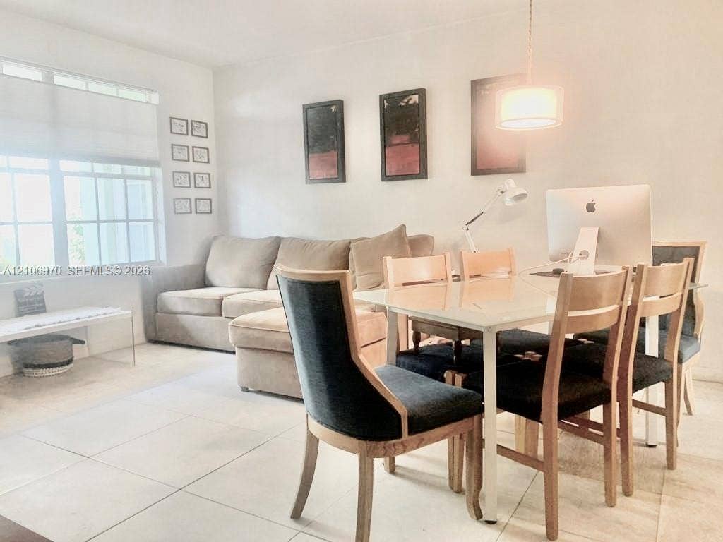 8540 Byron Avenue, #1B, Miami Beach, Miami Beach, FL 33141 Open-concept room featuring large-format ceramic tile flooring, multi-pane window with custom blind, and a central pendant light fixture