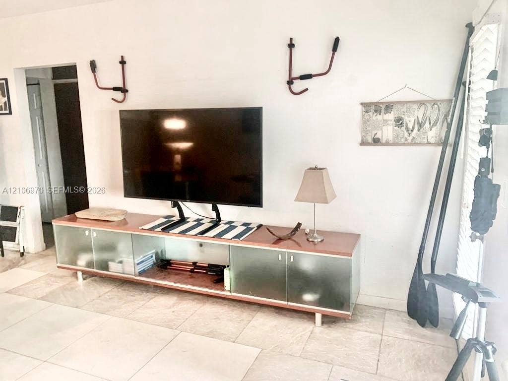 8540 Byron Avenue, #1B, Miami Beach, Miami Beach, FL 33141 Large format tile flooring with white plantation shutters and built-in glass-front cabinetry
