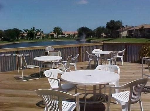 504 Gardens Drive, #101, Pompano Beach, Pompano Beach, FL 33069 Elevated wood deck featuring corrugated metal railing panels and pond frontage