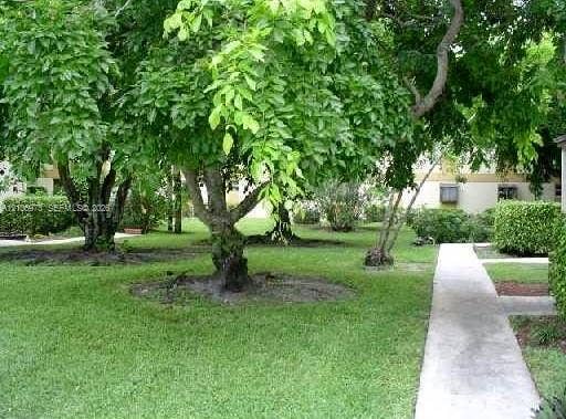504 Gardens Drive, #101, Pompano Beach, Pompano Beach, FL 33069 Landscaped grounds featuring manicured turf, mature deciduous trees, and concrete pathways