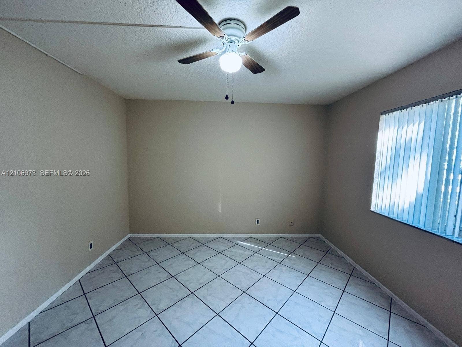 504 Gardens Drive, #101, Pompano Beach, Pompano Beach, FL 33069 Room featuring diagonal tile flooring, ceiling fan with integrated lighting, and vertical window blinds