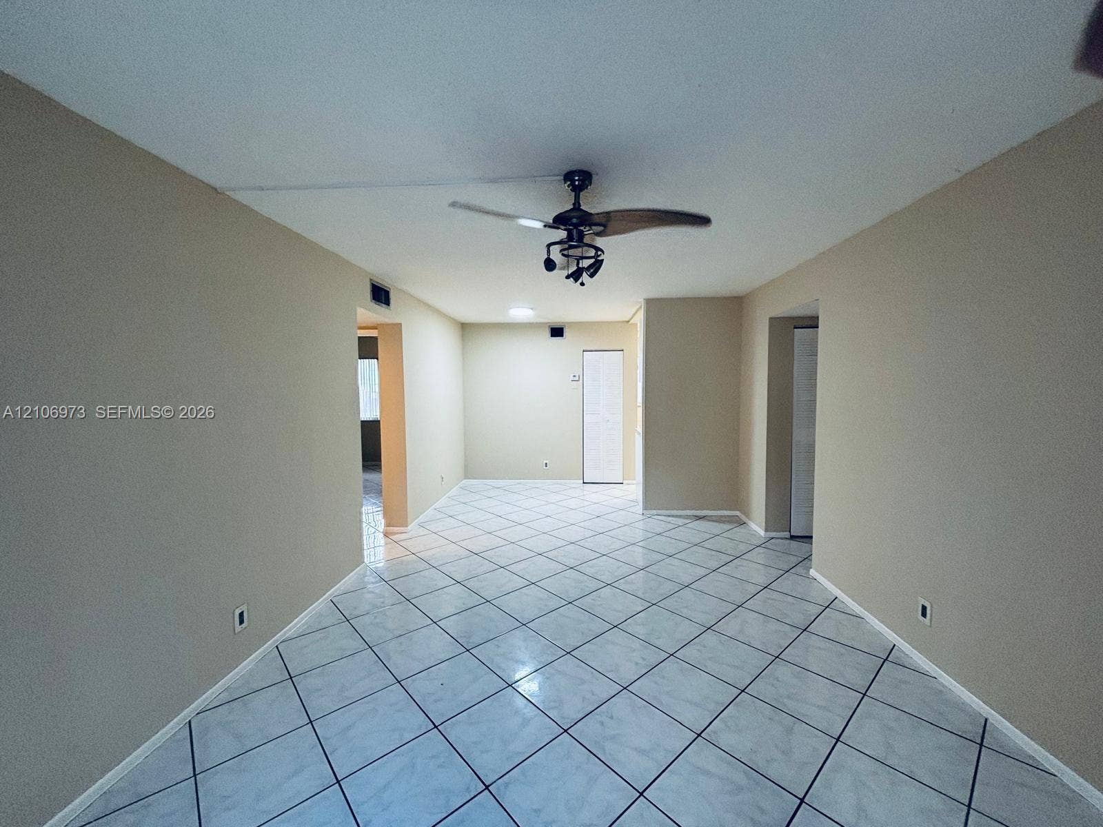 504 Gardens Drive, #101, Pompano Beach, Pompano Beach, FL 33069 Interior space featuring diagonal tile flooring, neutral wall tones, and a ceiling fan with integrated lighting