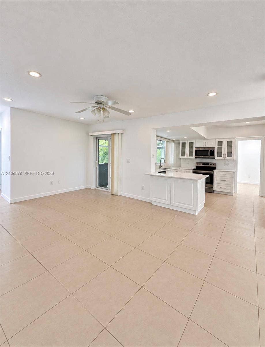 8376 NW 16th Street, Coral Springs, Coral Springs, FL 33071 Spacious open-concept living area featuring neutral tile flooring throughout, recessed ceiling lighting, and a ceiling fan