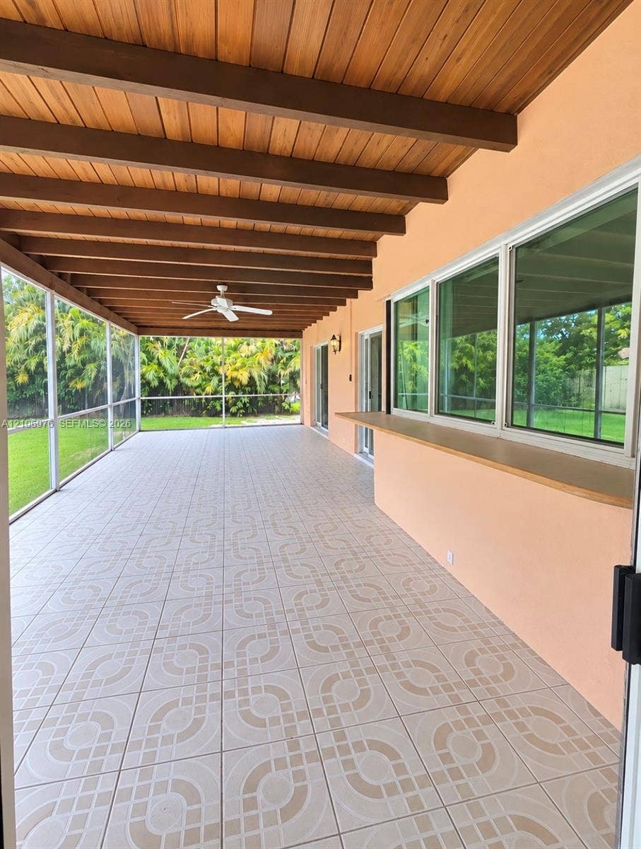 8376 NW 16th Street, Coral Springs, Coral Springs, FL 33071 Screened lanai featuring a wood-beam ceiling, patterned tile flooring, an integrated serving bar, and a ceiling fan