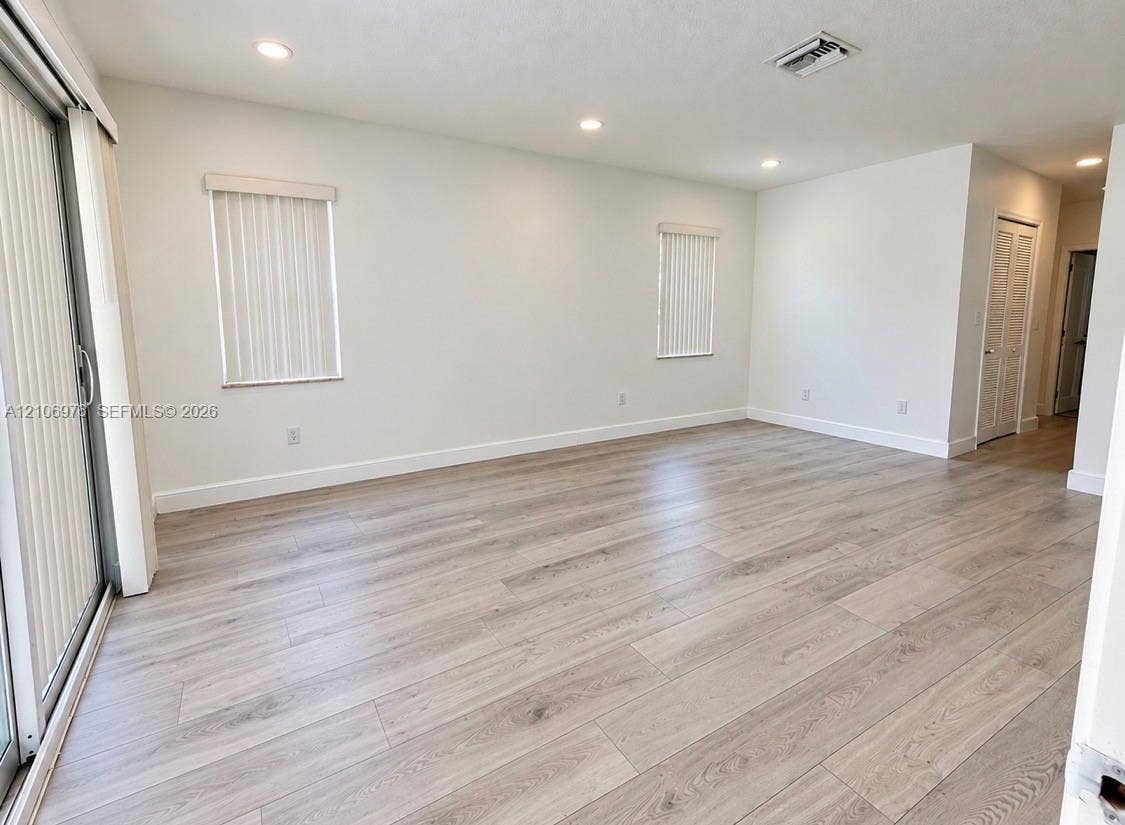 8376 NW 16th Street, Coral Springs, Coral Springs, FL 33071 Interior space featuring wood-finish flooring, recessed lighting, sliding glass door, and louvered-style closet doors
