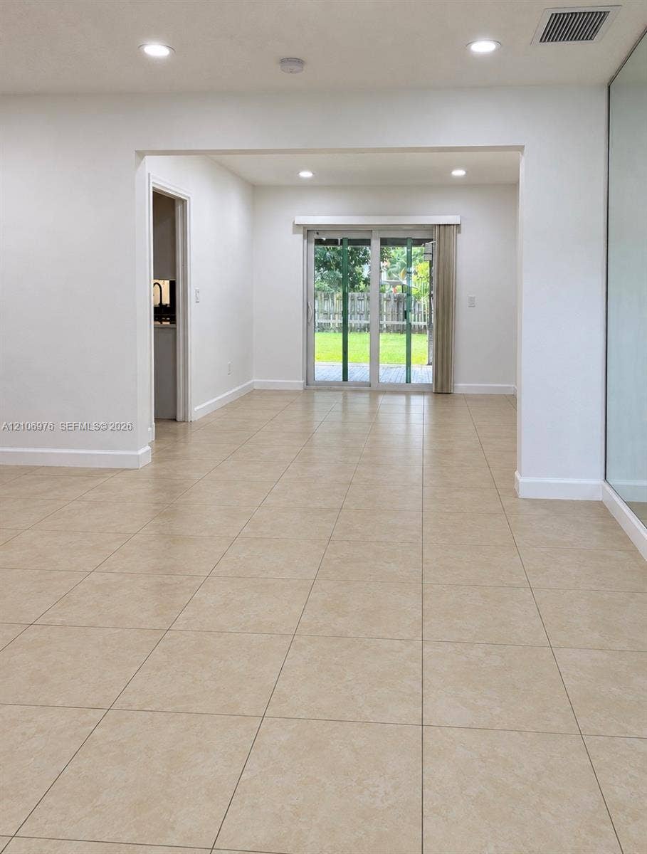 8376 NW 16th Street, Coral Springs, Coral Springs, FL 33071 Neutral ceramic tile flooring, recessed lighting, and sliding glass doors leading to a rear exterior space