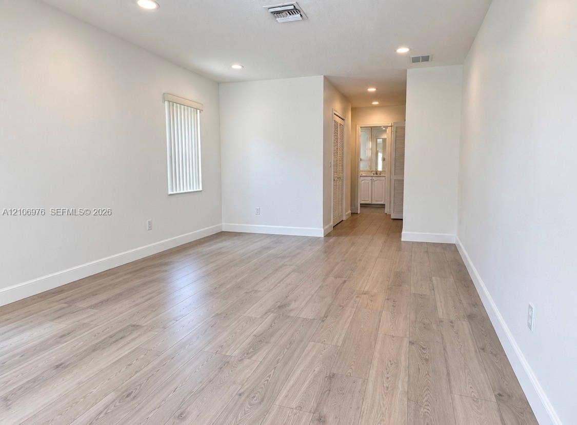 8376 NW 16th Street, Coral Springs, Coral Springs, FL 33071 Interior space featuring wood-finish flooring, recessed lighting, and a window with vertical blinds