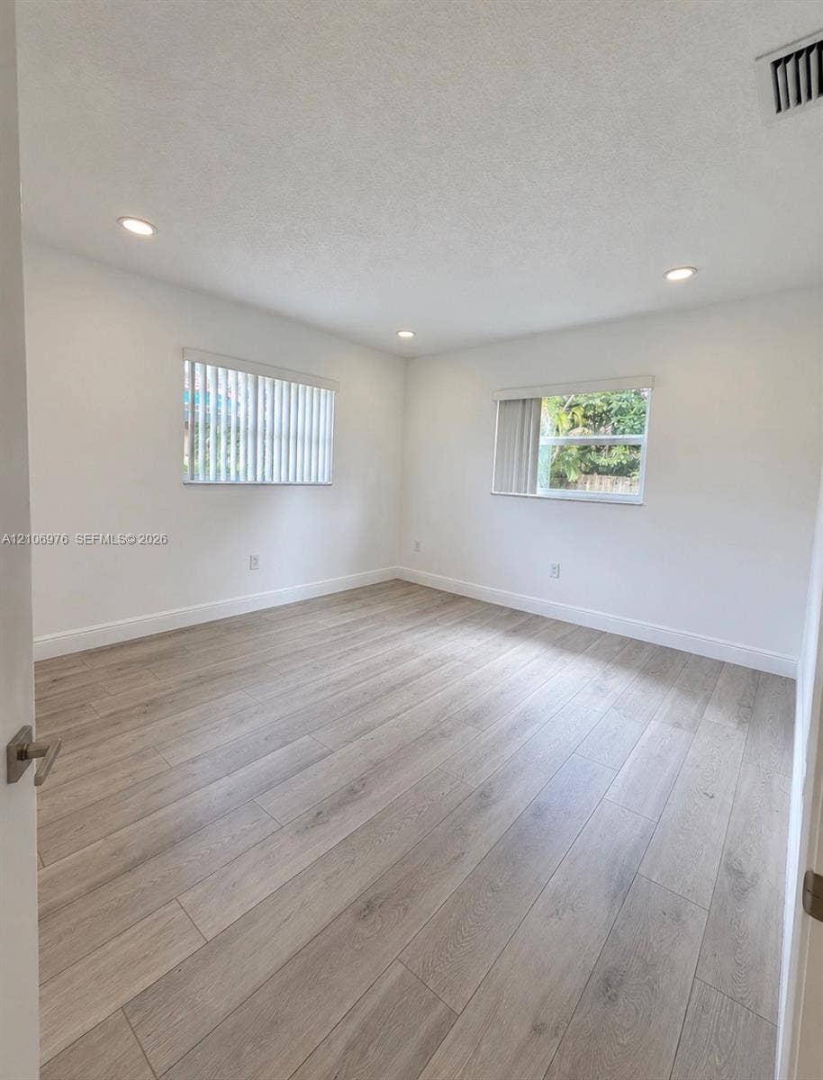 8376 NW 16th Street, Coral Springs, Coral Springs, FL 33071 Interior space featuring wood-finish flooring, recessed lighting, and dual windows with vertical blinds