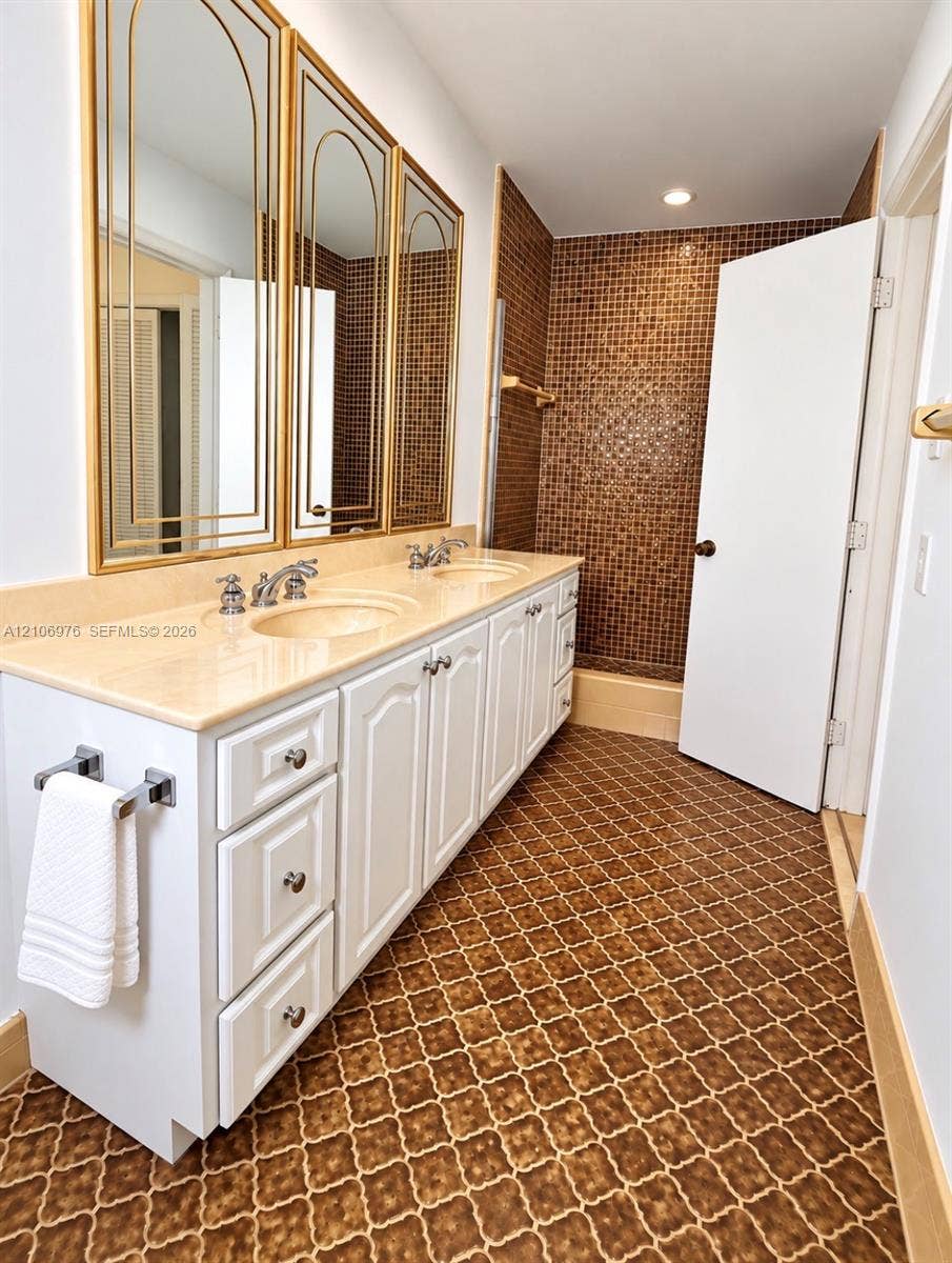 8376 NW 16th Street, Coral Springs, Coral Springs, FL 33071 Double vanity featuring white cabinetry, a solid-surface countertop with integrated sinks, and polished metal faucets
