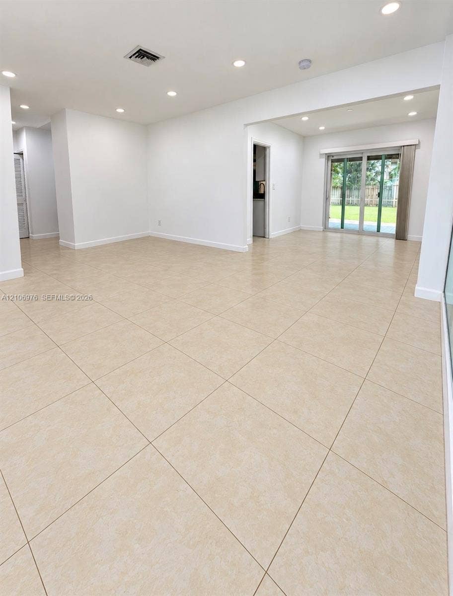 8376 NW 16th Street, Coral Springs, Coral Springs, FL 33071 Neutral-toned large-format tile flooring, recessed ceiling lighting, and sliding glass door leading to an outdoor space