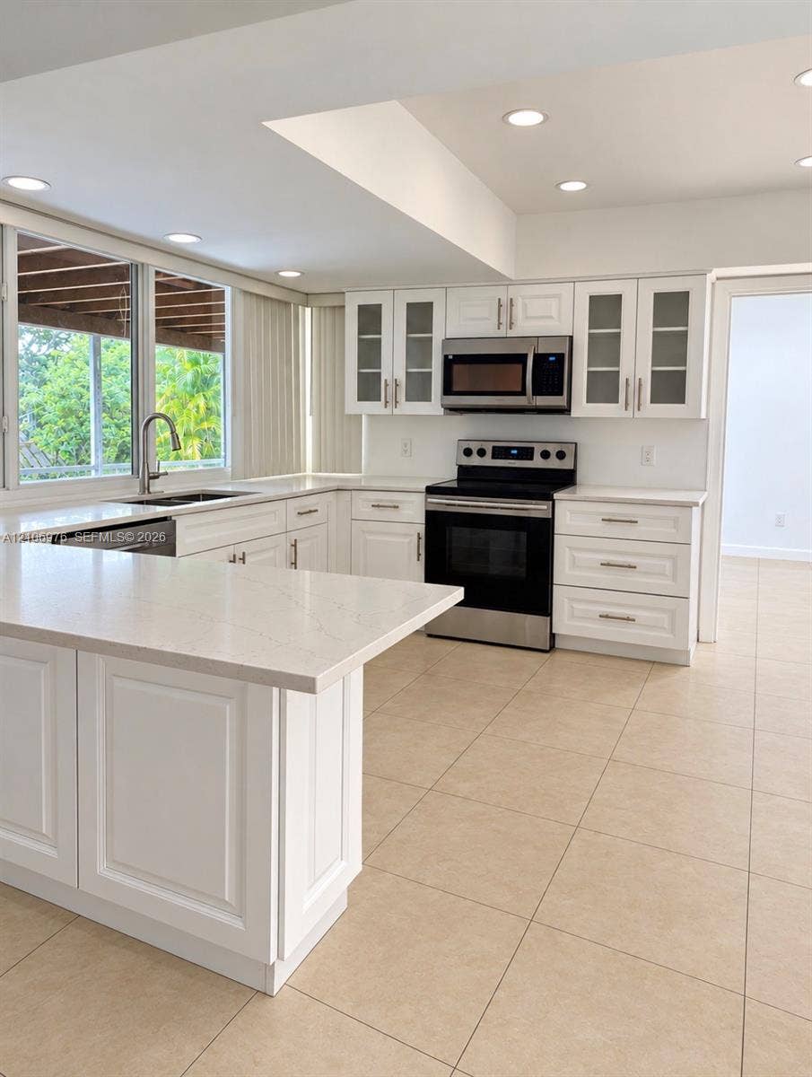 8376 NW 16th Street, Coral Springs, Coral Springs, FL 33071 Kitchen featuring white Shaker-style cabinetry, quartz countertops, stainless steel appliances, tile flooring, and glass-paneled upper cabinets
