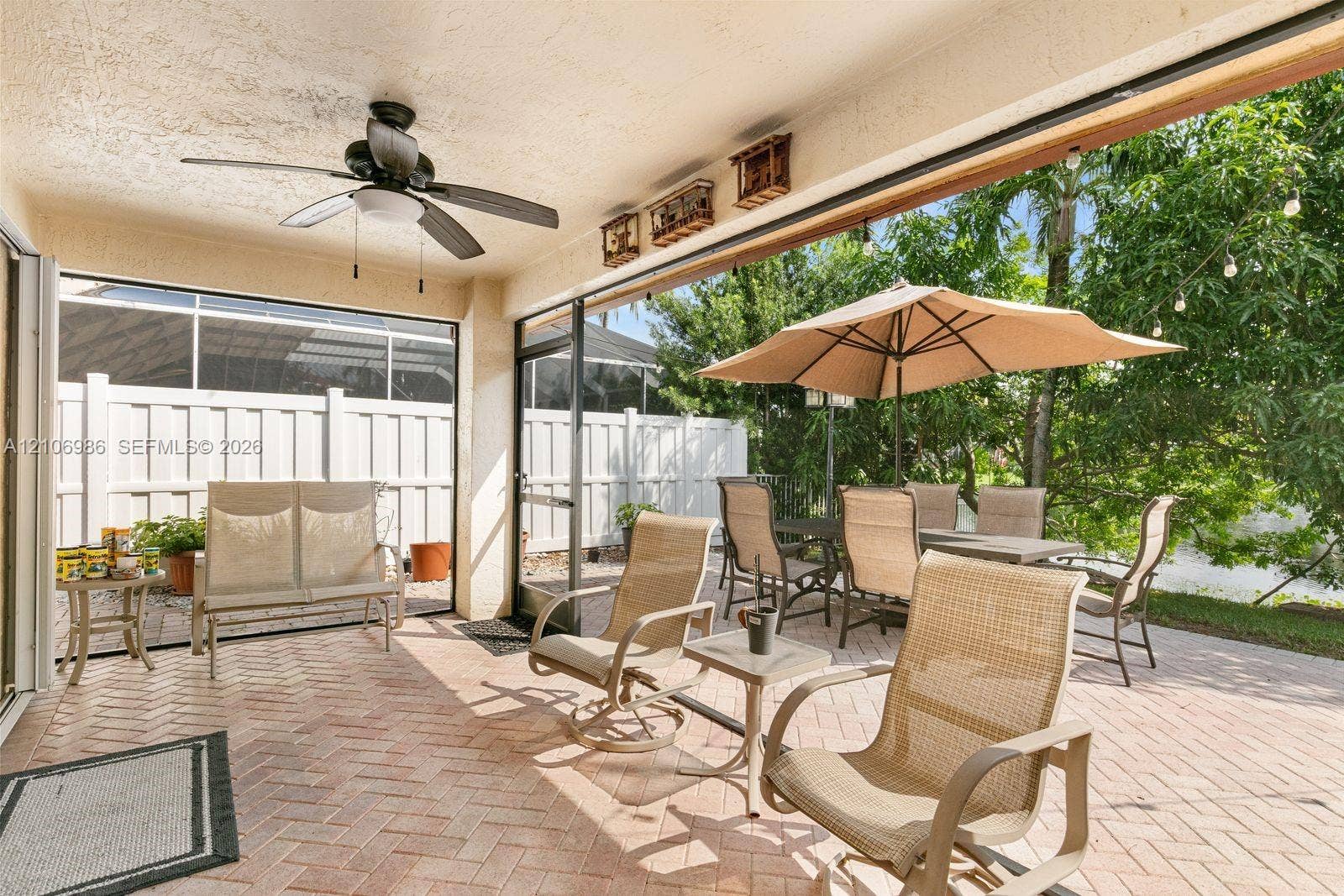 3801 SW 147th Avenue, Miramar, FL 33027 Covered patio featuring brick paver flooring, integrated ceiling fan, and screened enclosure