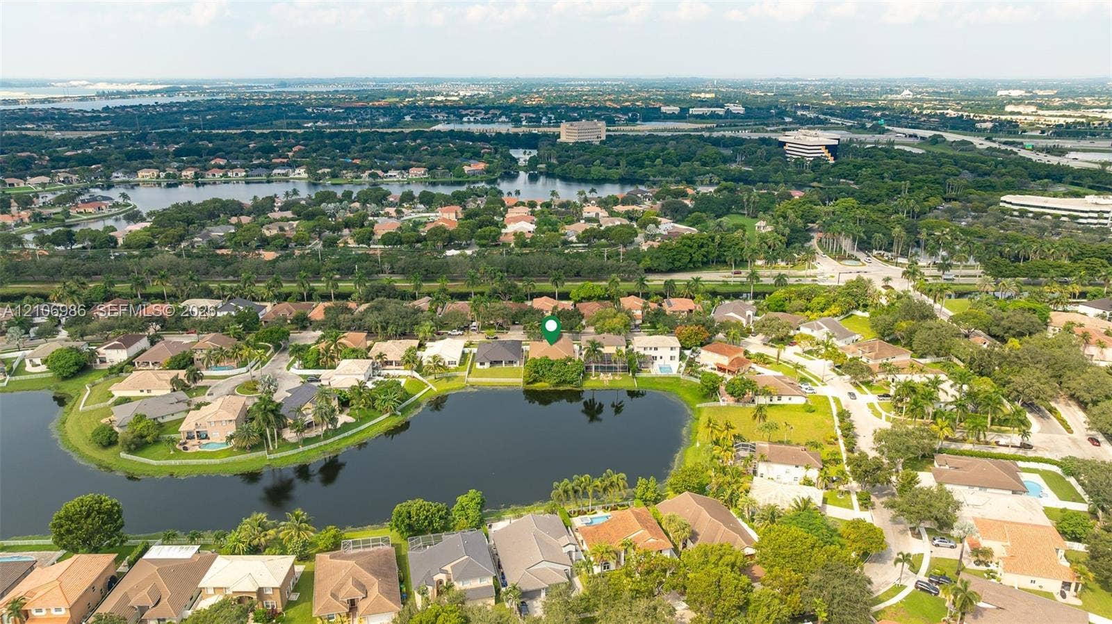 3801 SW 147th Avenue, Miramar, FL 33027 Aerial perspective of residential property featuring waterfront positioning, tile roof construction, and established perimeter vegetation