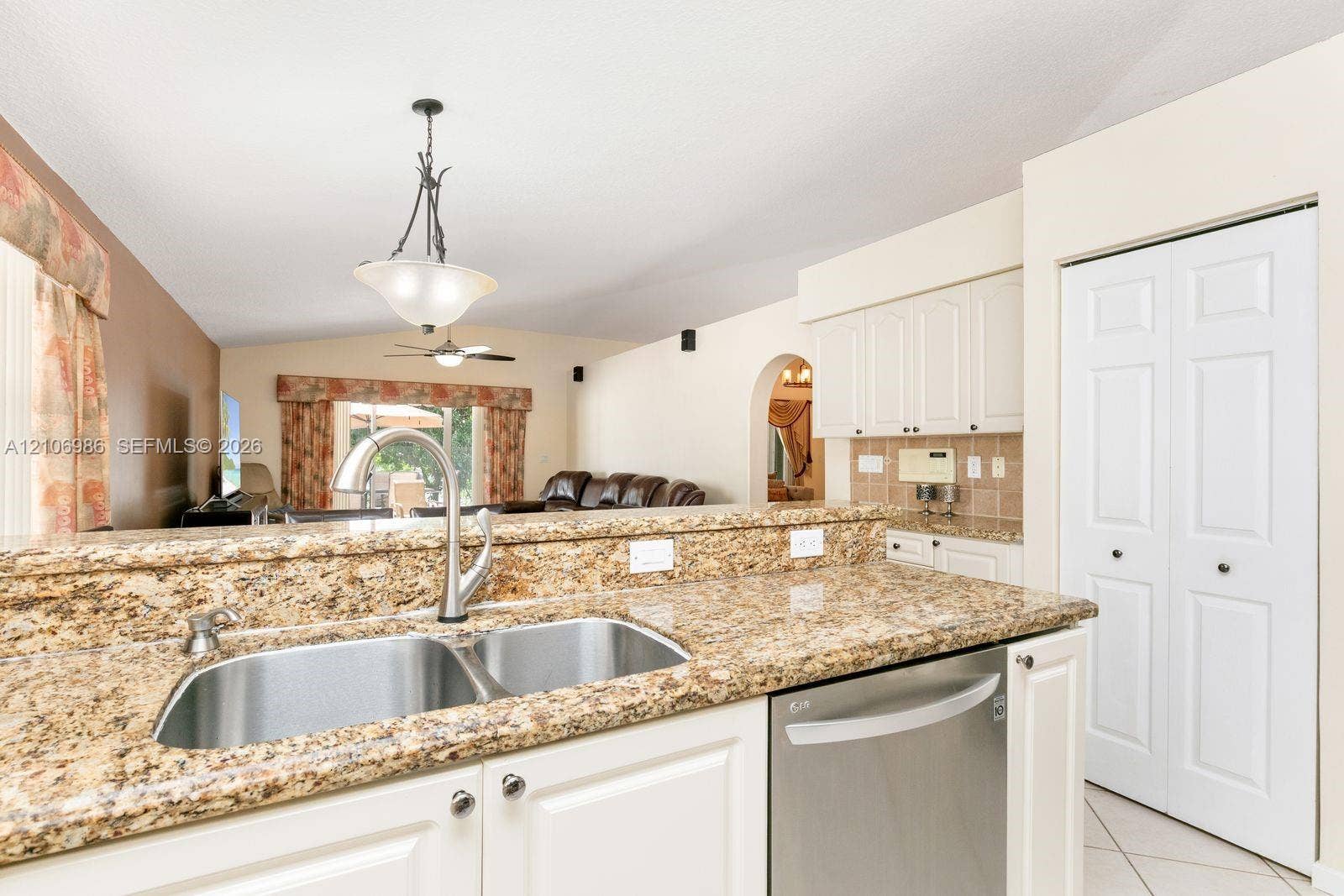 3801 SW 147th Avenue, Miramar, FL 33027 Kitchen featuring stone countertops, white cabinetry, stainless steel dishwasher, dual-basin stainless steel sink, and decorative pendant lighting