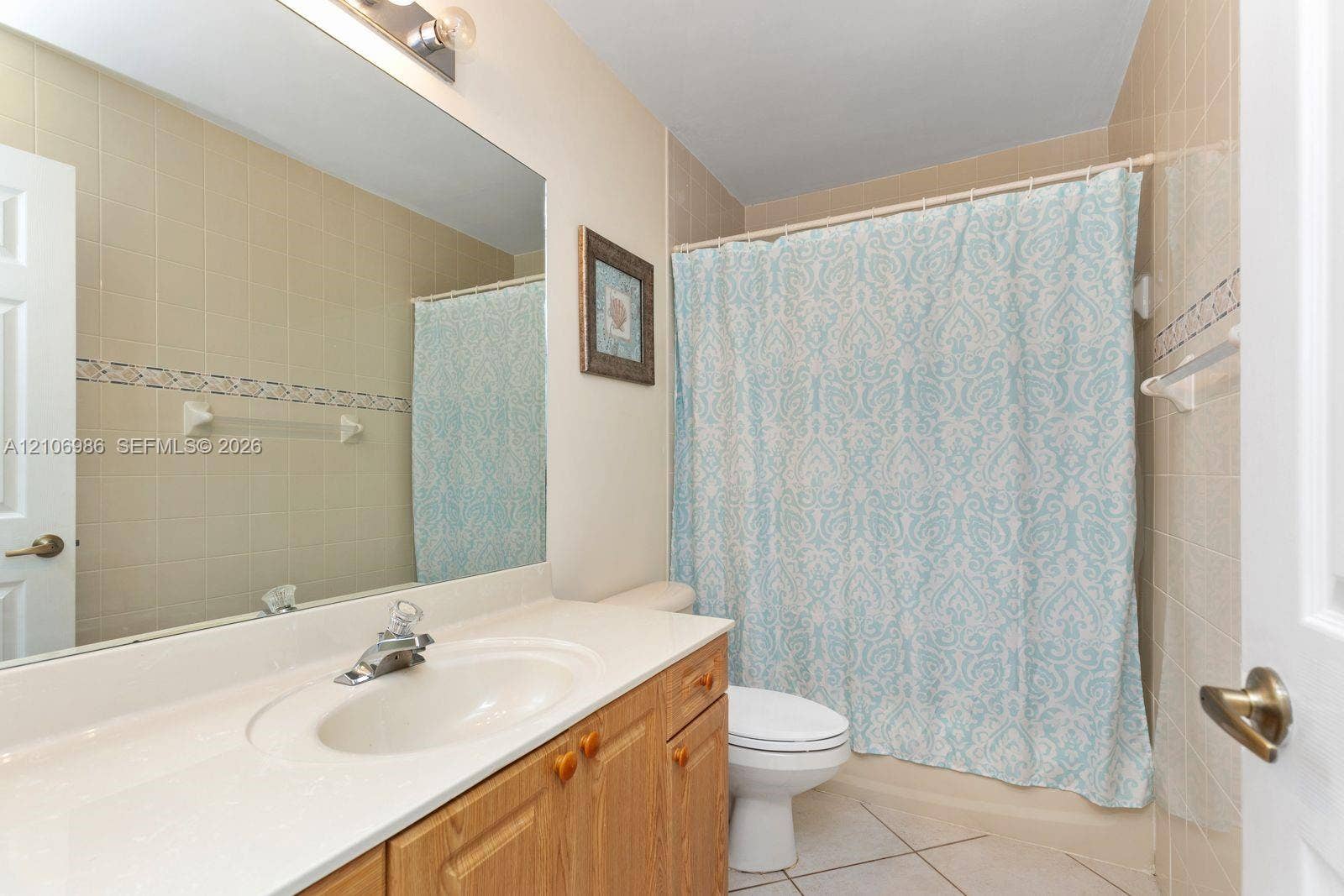3801 SW 147th Avenue, Miramar, FL 33027 Bathroom featuring a vanity with a white countertop and integrated sink, a full-width wall mirror, tile flooring, and a tiled shower surround