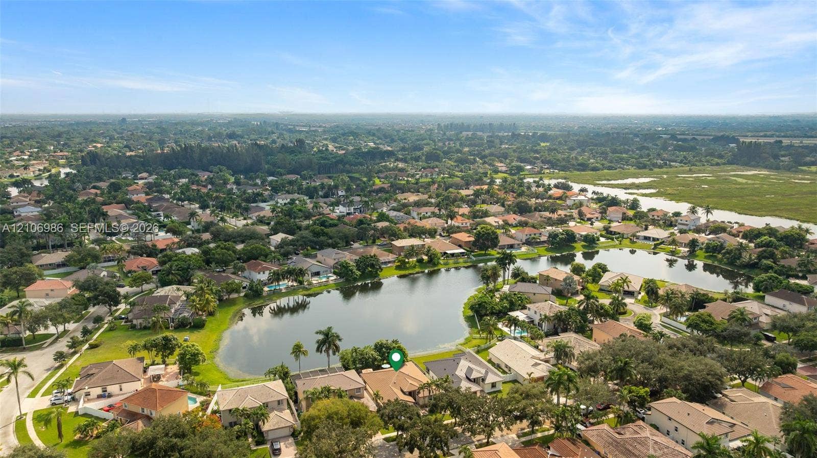 3801 SW 147th Avenue, Miramar, FL 33027 Aerial perspective featuring a single-story residence situated on a waterfront lot with mature landscaping
