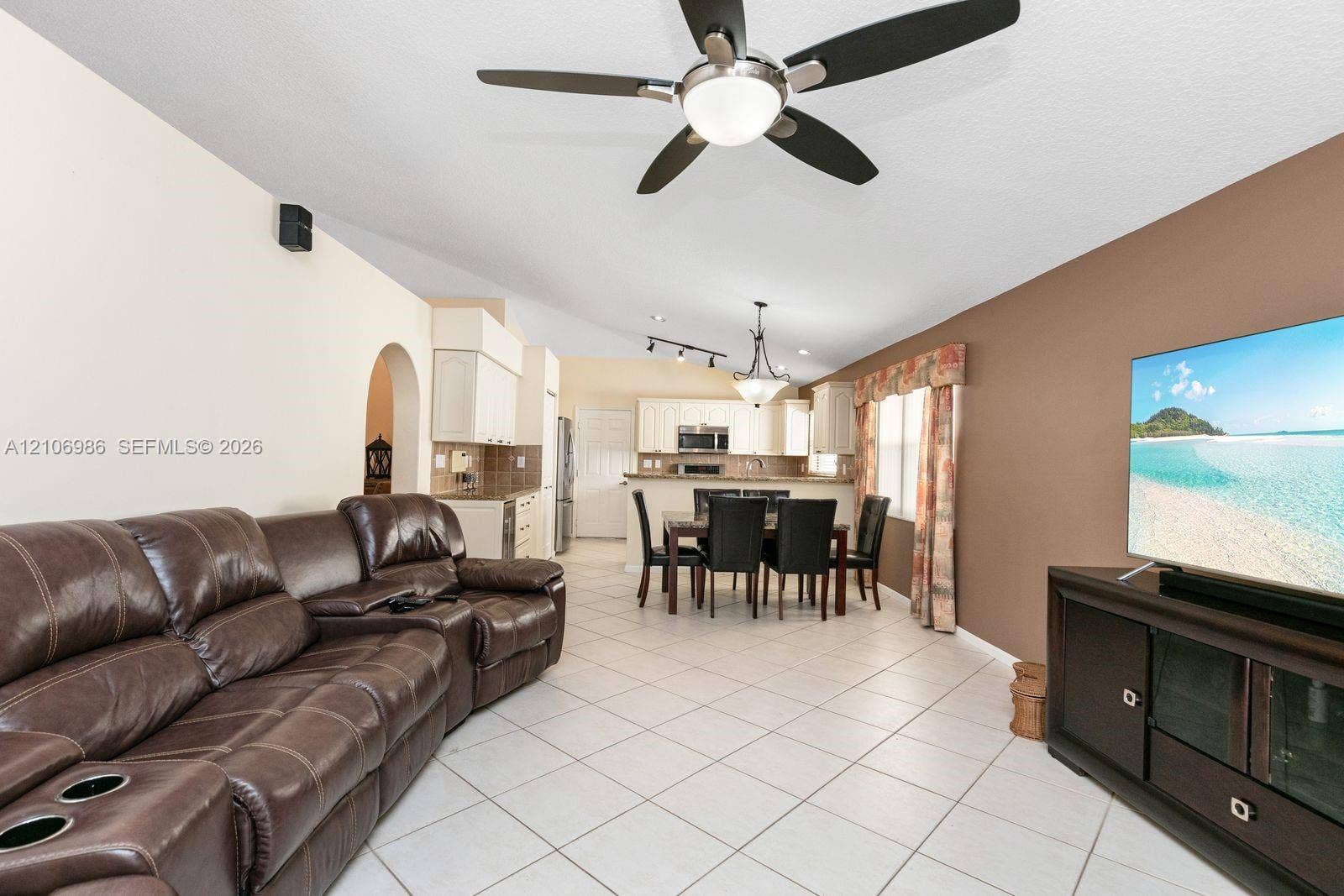 3801 SW 147th Avenue, Miramar, FL 33027 Open-concept interior featuring light-toned tile flooring, vaulted ceilings with a center-mounted ceiling fan, and track lighting