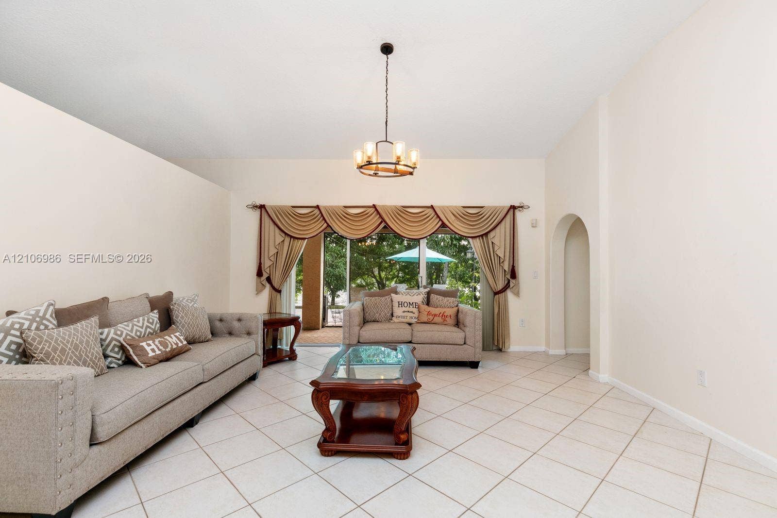 3801 SW 147th Avenue, Miramar, FL 33027 High ceilings with a central chandelier, ceramic tile flooring, and an arched architectural opening