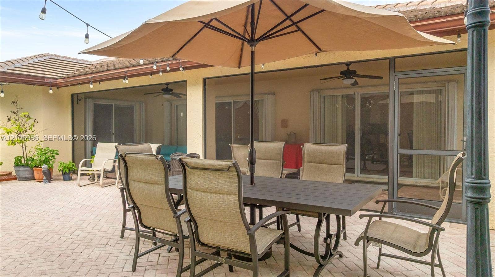 3801 SW 147th Avenue, Miramar, FL 33027 Covered patio featuring a paved brick surface, screen enclosure, and ceiling fans