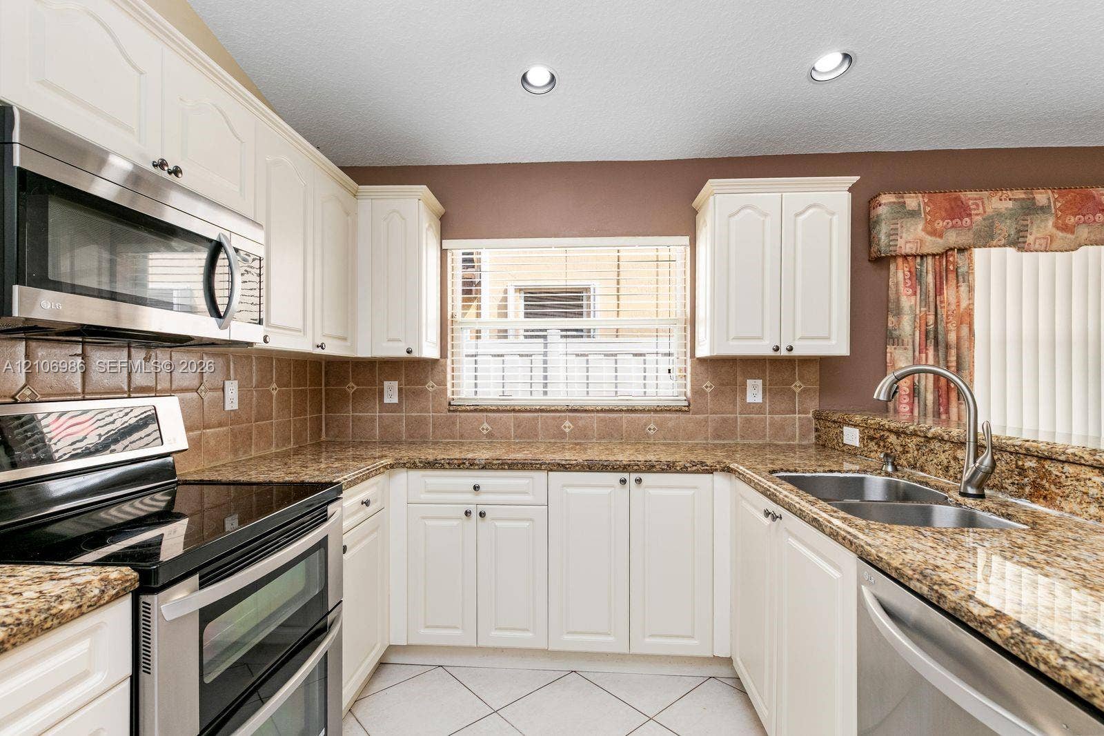 3801 SW 147th Avenue, Miramar, FL 33027 Kitchen featuring white cabinetry, stone countertops, square tile backsplash, recessed lighting, and stainless steel appliances