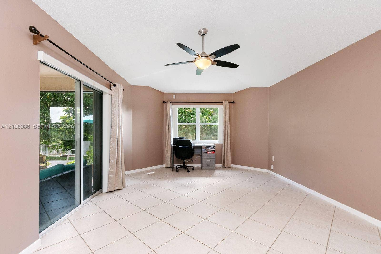 3801 SW 147th Avenue, Miramar, FL 33027 Room featuring light-toned tile flooring, large sliding glass doors, a dual-pane window, and a ceiling fan with integrated light fixture
