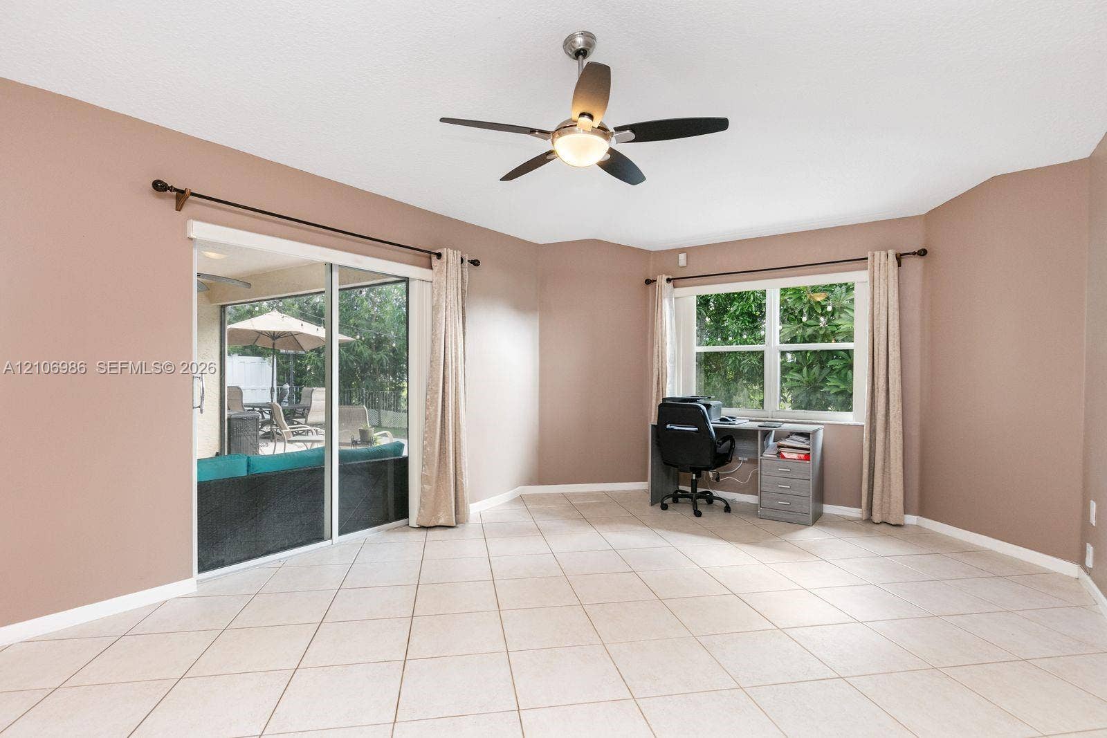 3801 SW 147th Avenue, Miramar, FL 33027 Large room featuring neutral tile flooring, a multi-blade ceiling fan with integrated lighting, sliding glass doors, and dual-pane windows