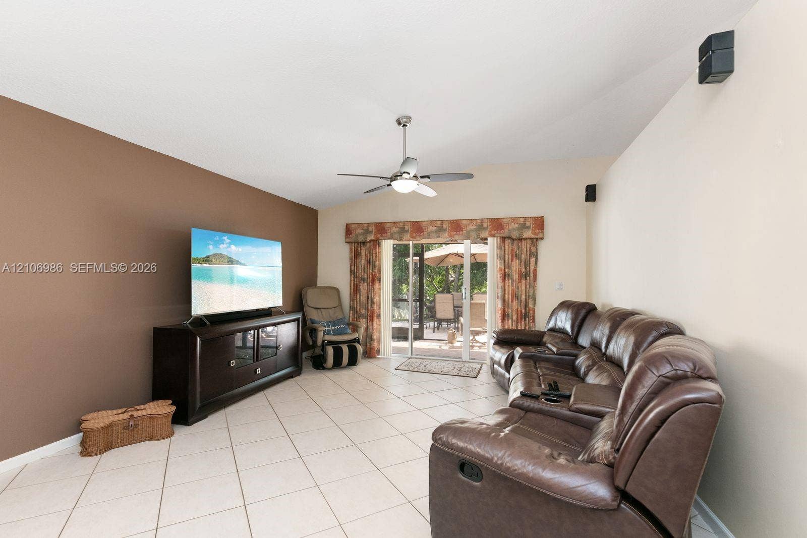 3801 SW 147th Avenue, Miramar, FL 33027 Living space featuring vaulted ceilings, neutral ceramic tile flooring, a ceiling fan with integrated lighting, and sliding glass doors