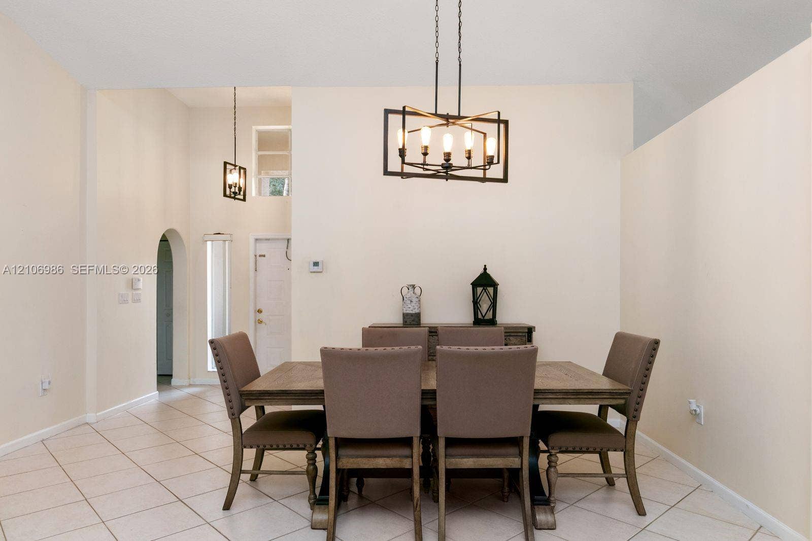 3801 SW 147th Avenue, Miramar, FL 33027 Vaulted ceilings featuring geometric metal chandeliers, ceramic tile flooring, and an arched entryway