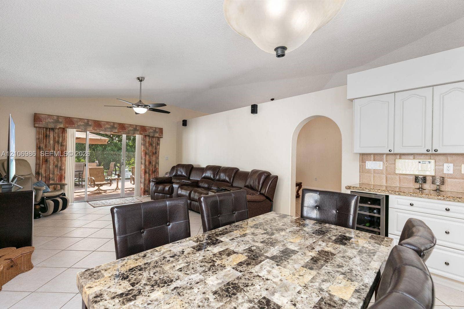 3801 SW 147th Avenue, Miramar, FL 33027 Vaulted ceilings, built-in beverage refrigerator, arched doorway, ceiling fan, and sliding glass doors