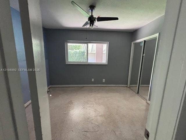 Room featuring a horizontal sliding window, mirrored sliding closet doors, and a ceiling fan with integrated light fixture