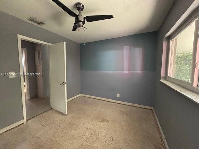 Interior room featuring dual-tone wall paint, a multi-blade ceiling fan with integrated lighting, and a window with a stone-finish sill