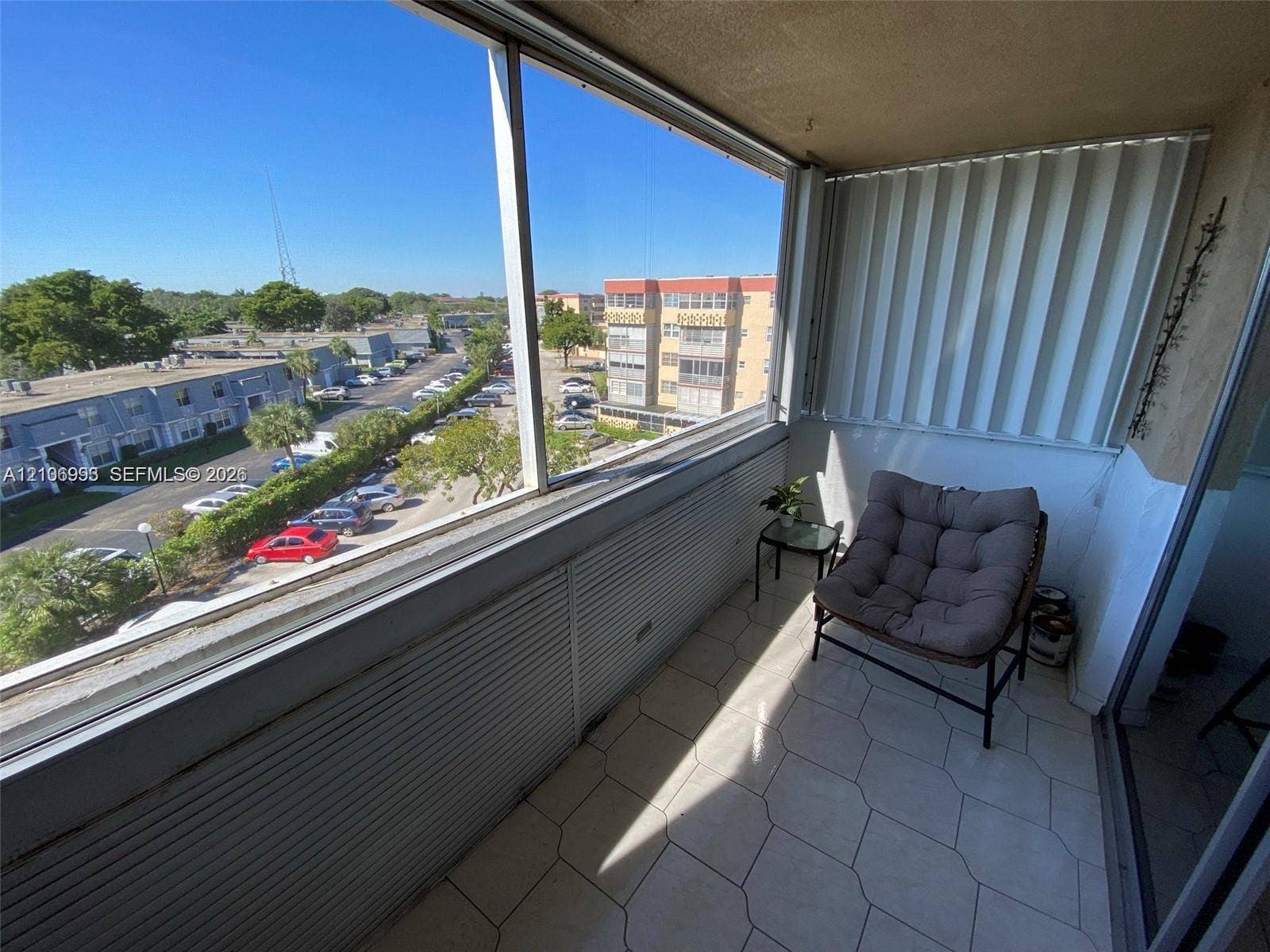 410 NW 68th Avenue, #515, Plantation, Plantation, FL 33317 Enclosed balcony featuring tile flooring, floor-to-ceiling glass paneling, and accordion-style storm shutters