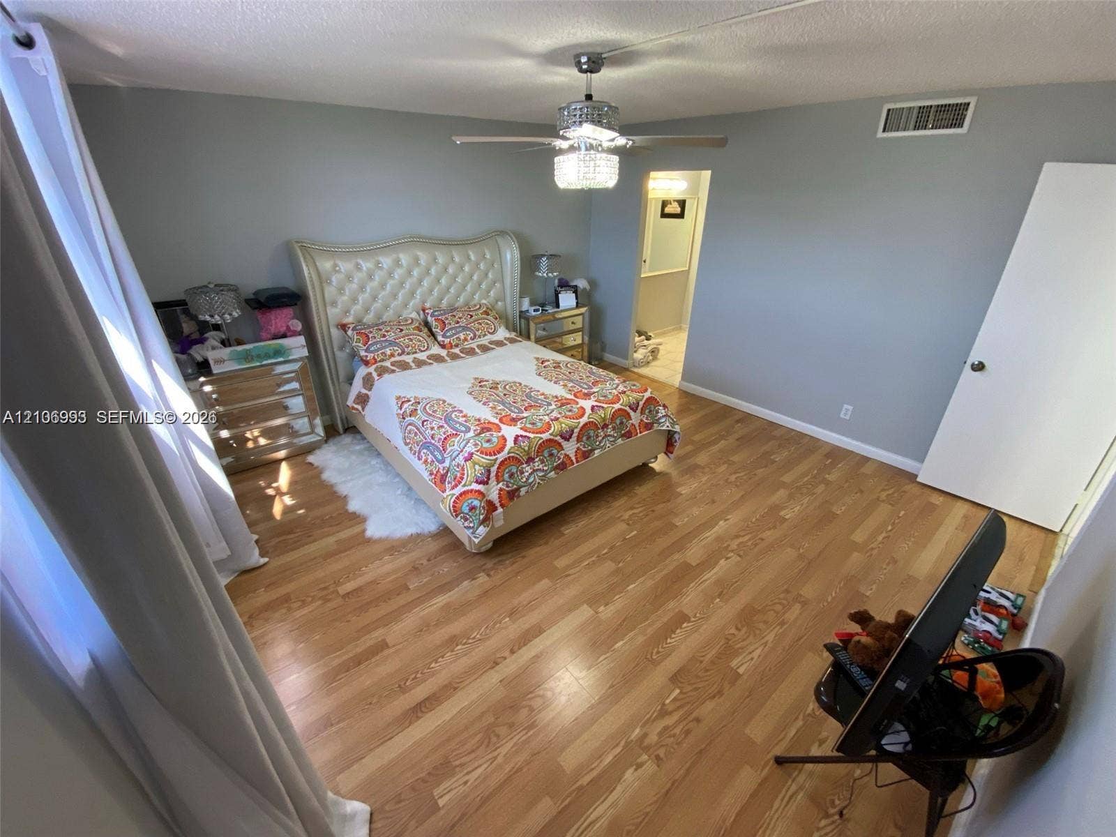 410 NW 68th Avenue, #515, Plantation, Plantation, FL 33317 Bedroom featuring wood-finish flooring, a multi-blade ceiling fan with an integrated crystal-style light fixture, and neutral wall paint
