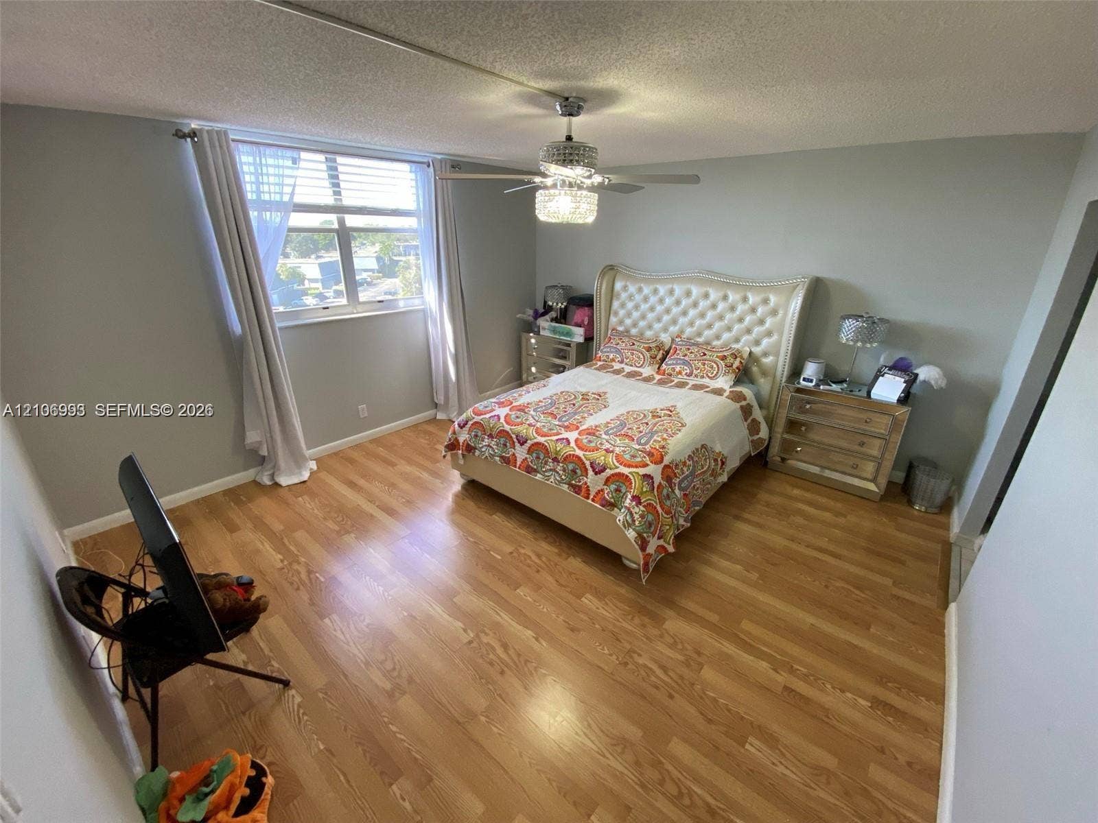 410 NW 68th Avenue, #515, Plantation, Plantation, FL 33317 Bedroom featuring wood-finish flooring, a crystal-accented ceiling fan with integrated lighting, and a window with horizontal blinds