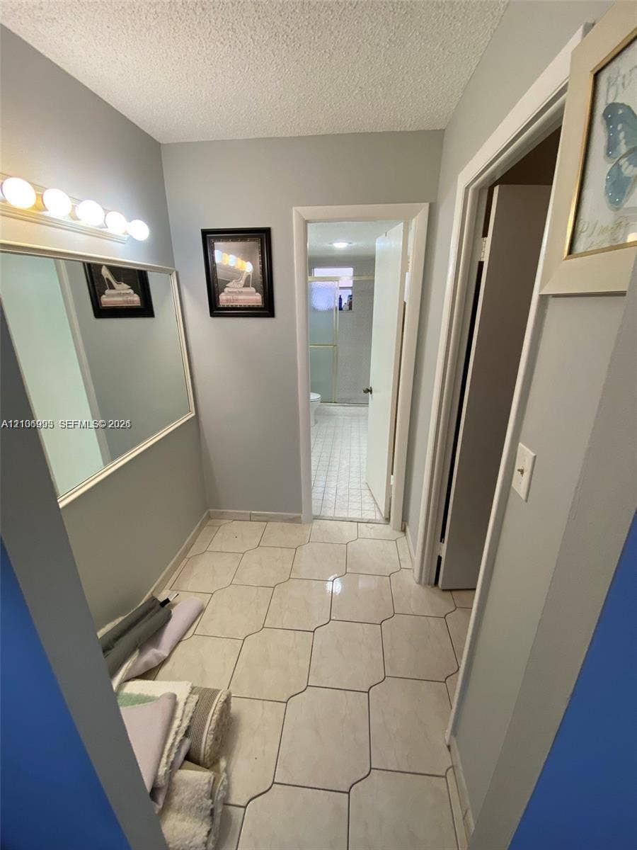 410 NW 68th Avenue, #515, Plantation, Plantation, FL 33317 Wall-mounted mirror with a five-light vanity fixture and large-format ceramic tile flooring