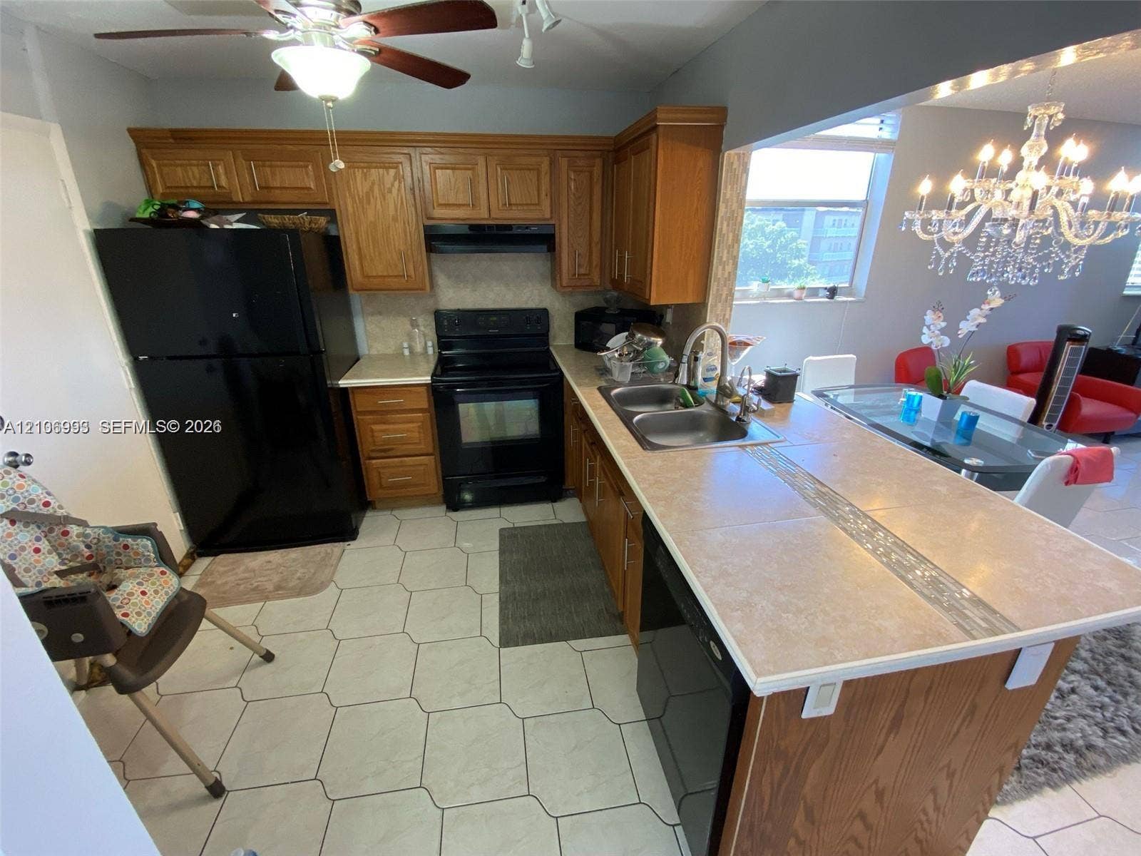 410 NW 68th Avenue, #515, Plantation, Plantation, FL 33317 Kitchen featuring wood cabinetry, a tiled countertop peninsula with an integrated double basin sink, and hexagonal floor tile