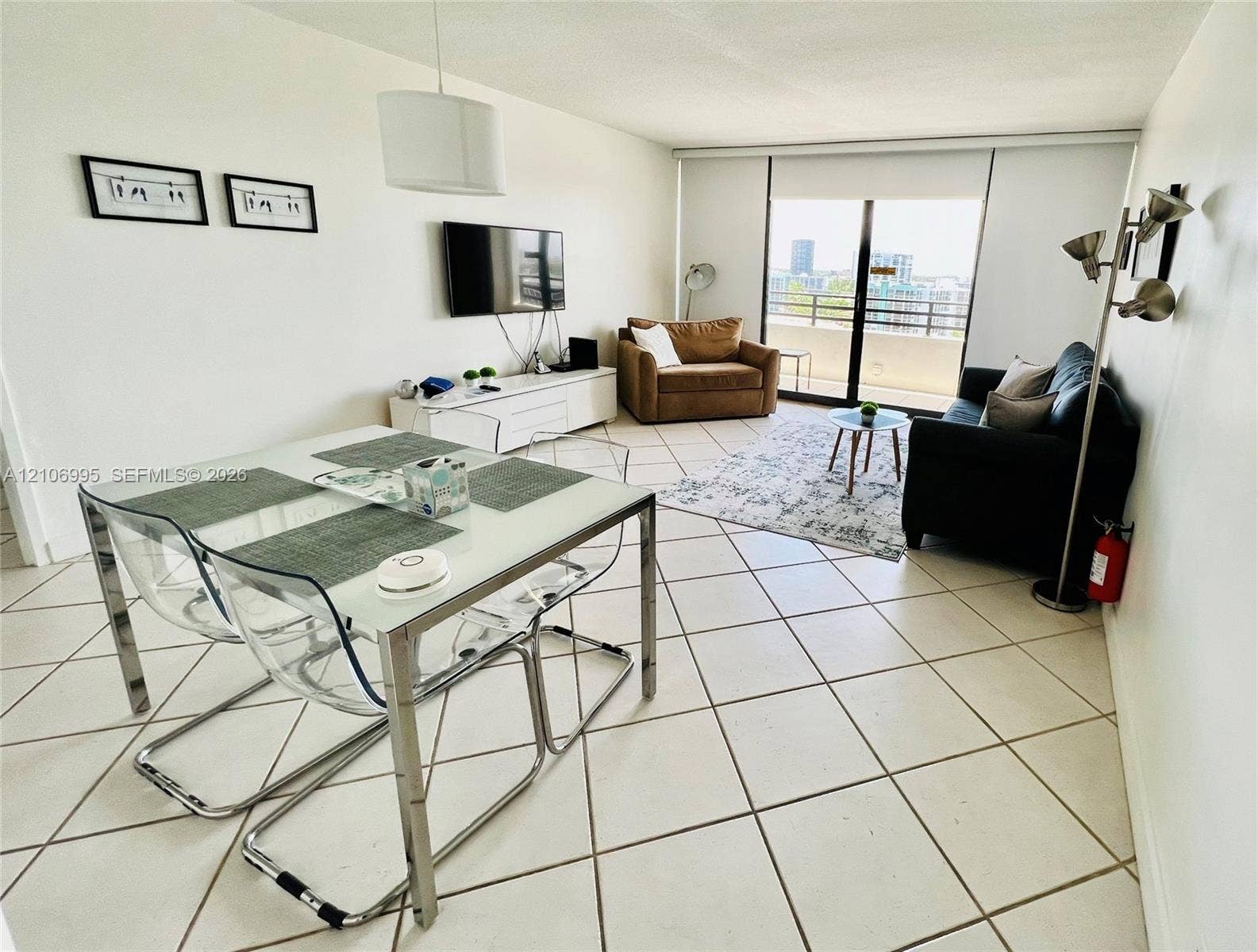3505 S Ocean Drive, #1404, Hollywood, FL 33019 Open-concept interior featuring oversized ceramic tile flooring, a neutral color palette, and sliding glass doors leading to a private balcony
