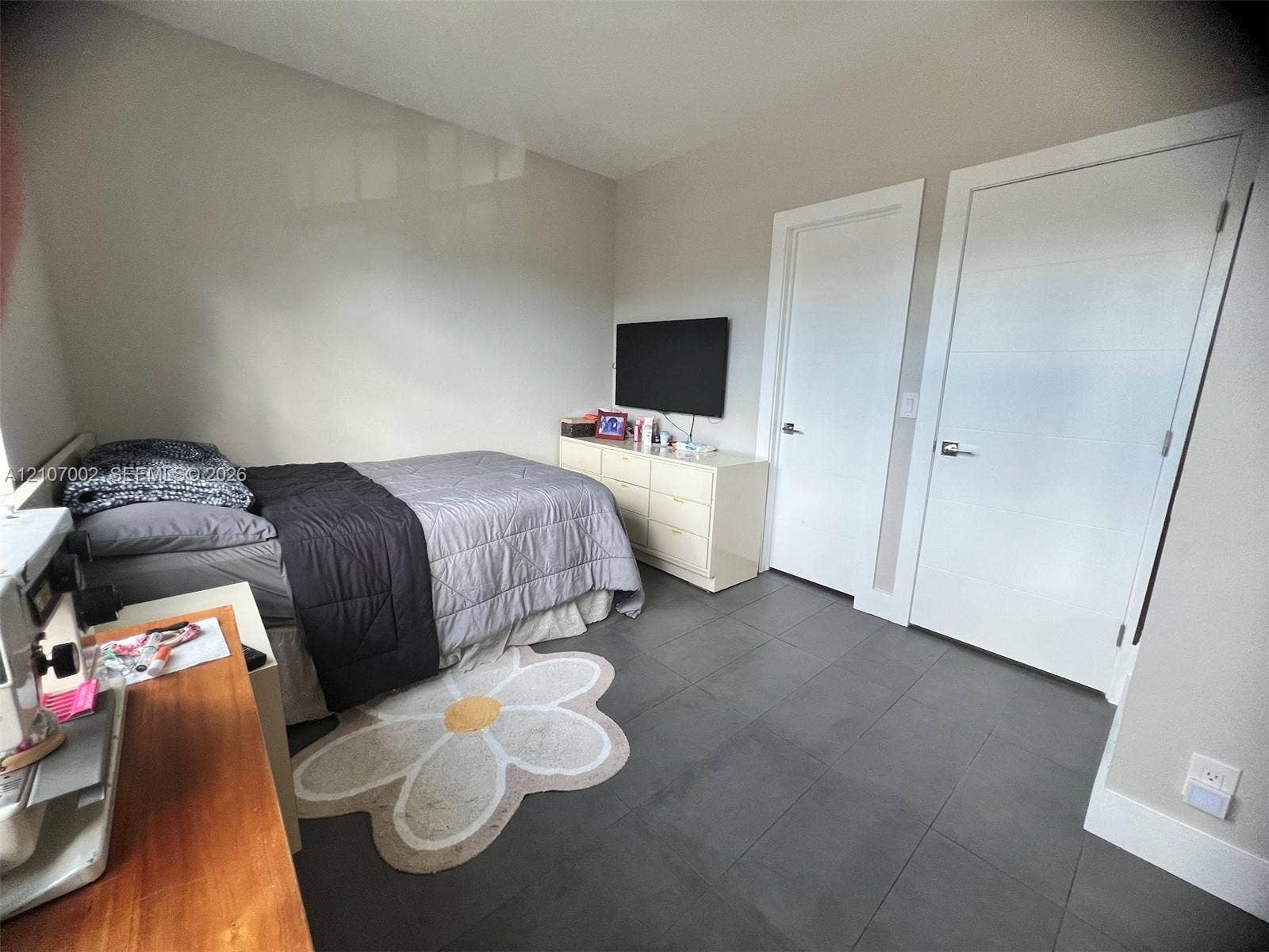 Large-format tile flooring, neutral wall tones, and two solid-core interior doors with satin nickel hardware